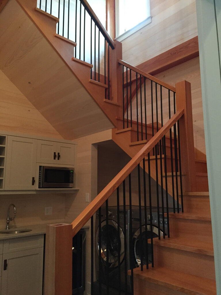 A wooden staircase is shown leading to a laundry area.